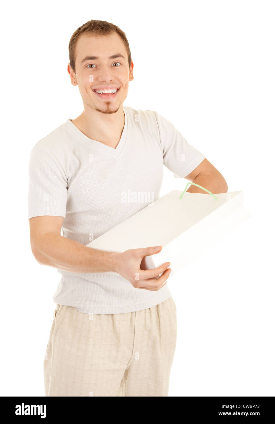 Glad handsome man is checking inside white gift paper bag. Isolated on white background. Stock Photo