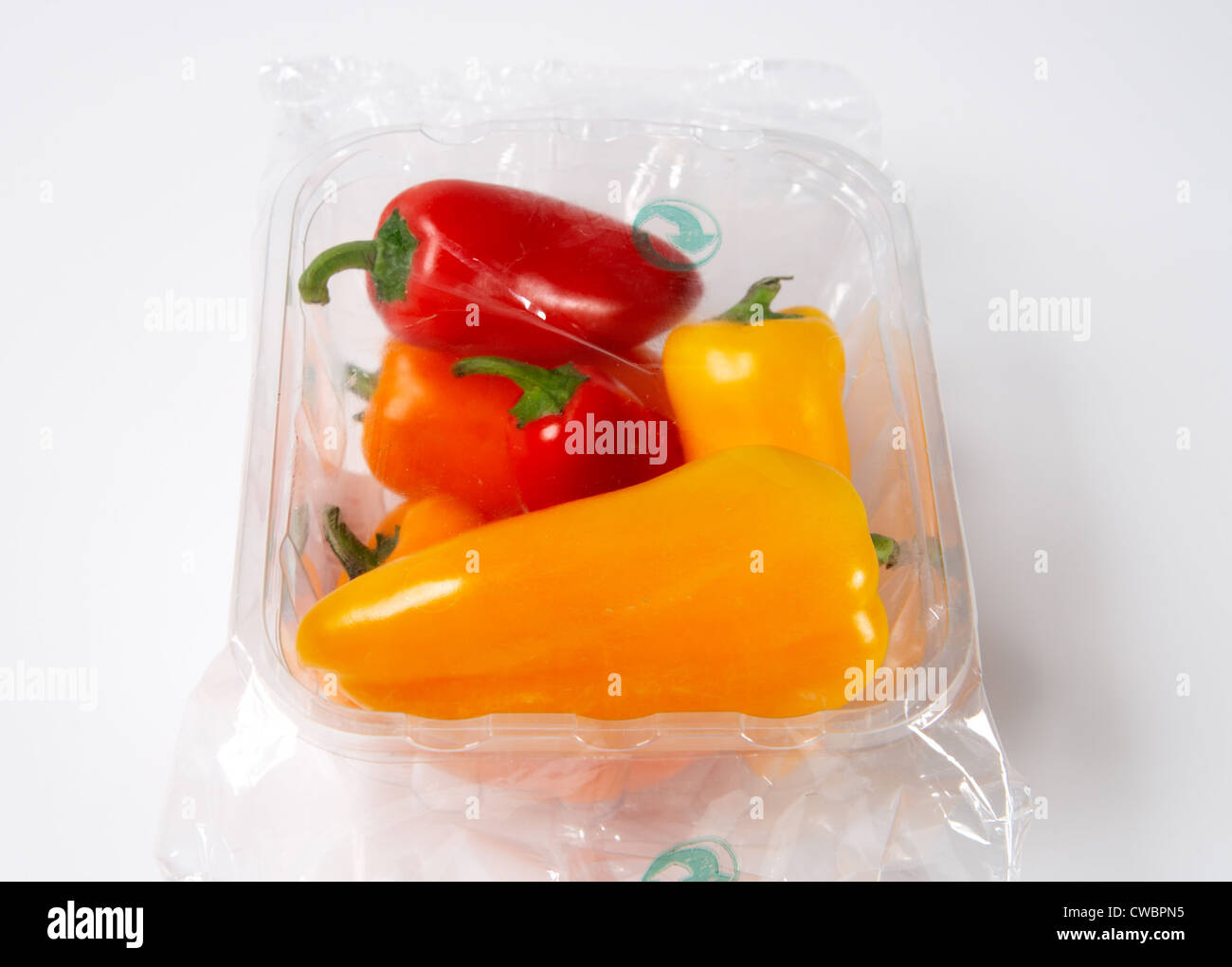 Colorful mini peppers wrapped with foil in a plastic tray Stock Photo