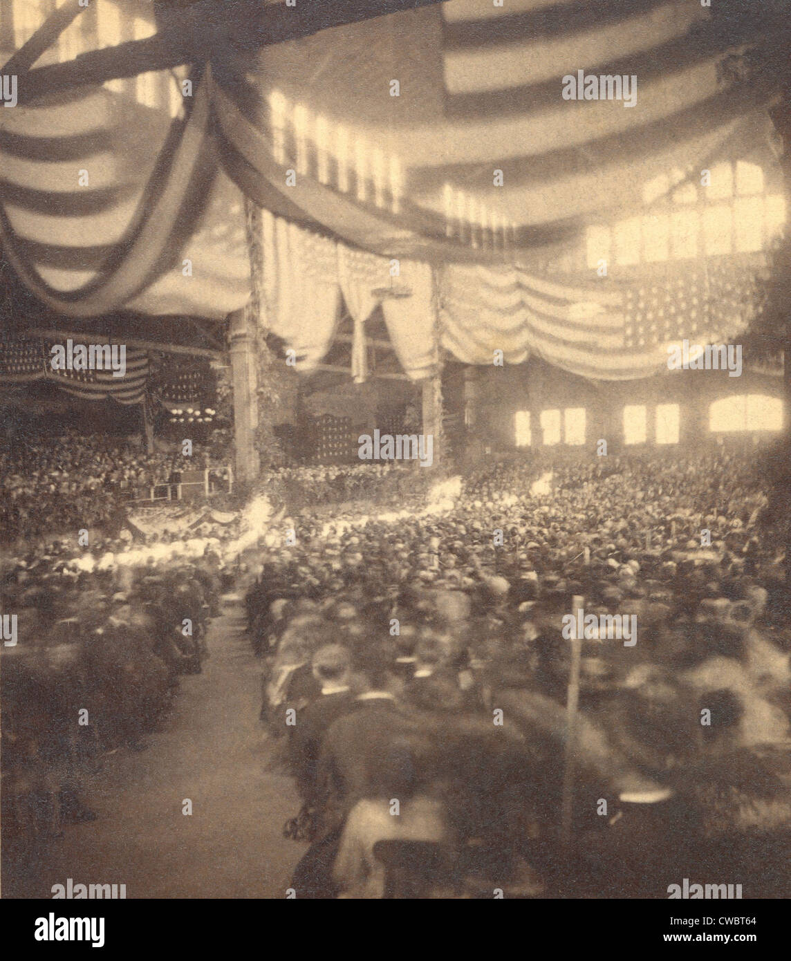 Interior view of a large convention hall filled with seated people. The 35-star flags decorating the hall allow the image to be Stock Photo