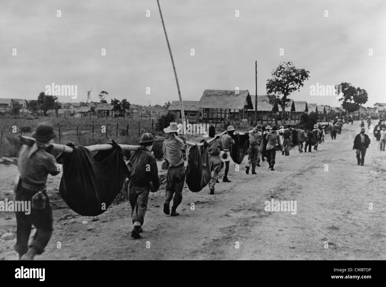 Near end of the Bataan Death March, US prisoners of war carry dead comrades in improvised stretchers of bamboo poles and Stock Photo