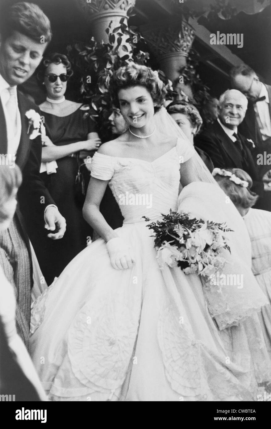 Jacqueline Bouvier Kennedy emerging from St. Mary's church in Newport Rhode, Island, on her wedding day. At far left is Senator Stock Photo