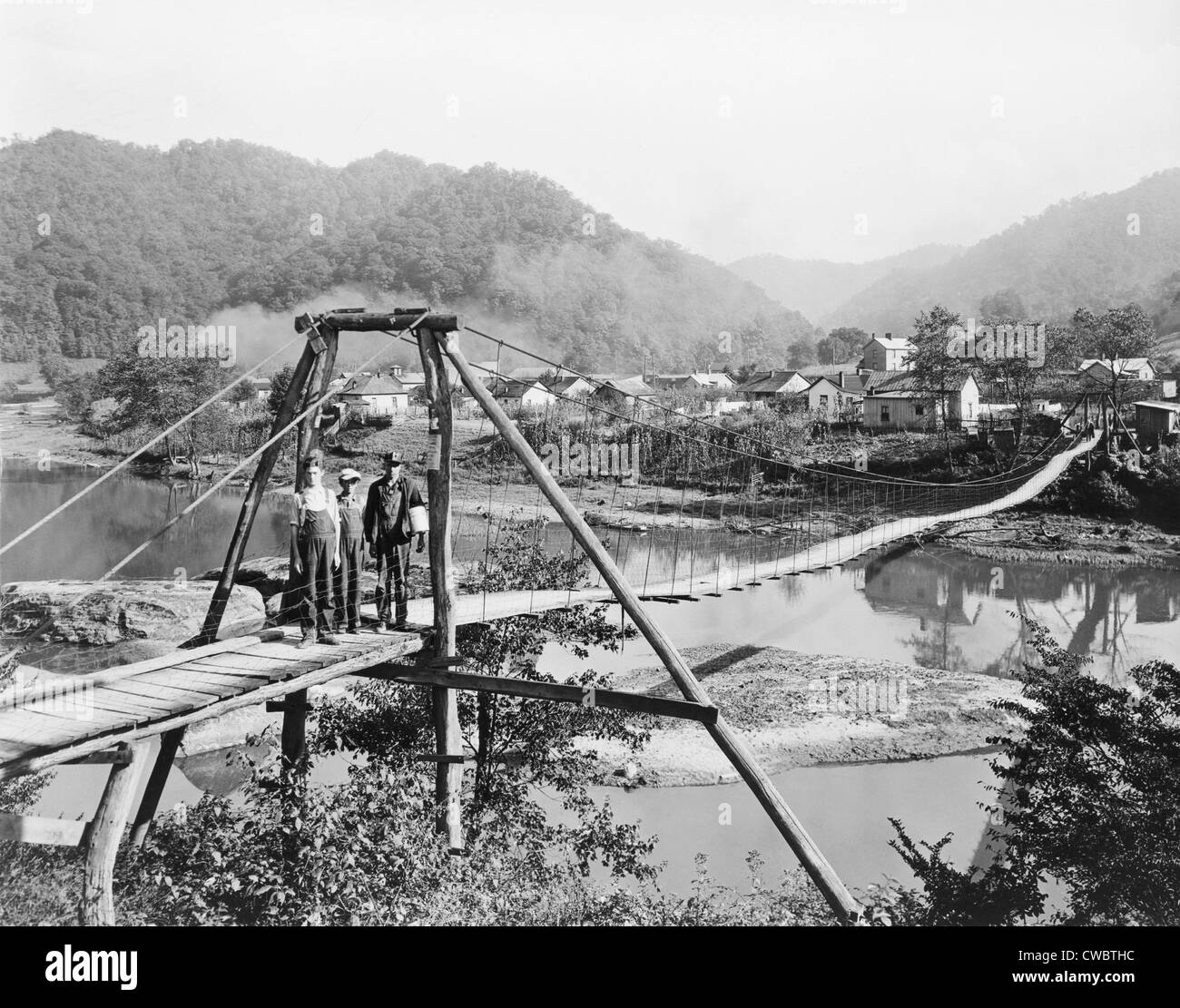A foot bridge on the Cumberland River, Wilhoit, Harlan County, Kentucky in 1929. The mountainous county's economy was based on Stock Photo