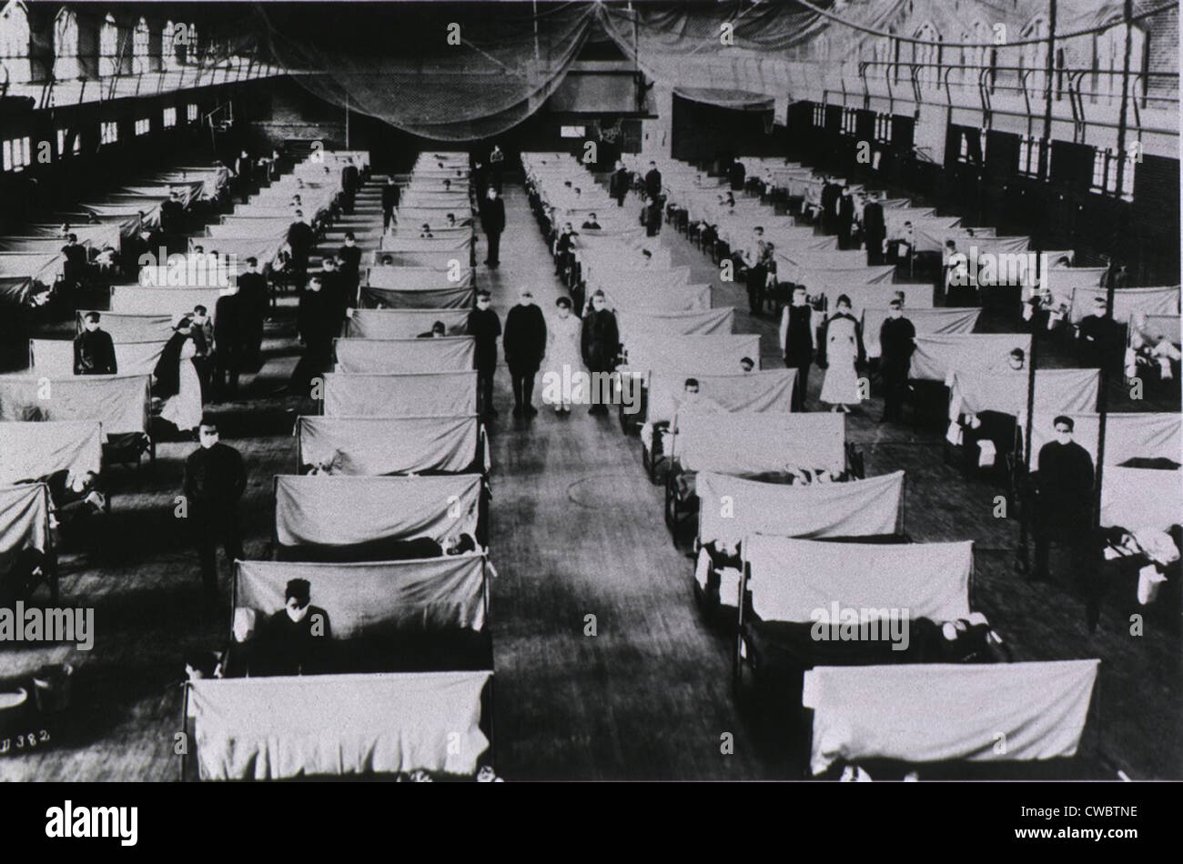 Spanish Flu Epidemic 1918-19. U.S. school gymnasium converted into an flu ward with patients' beds are separated by screens and Stock Photo