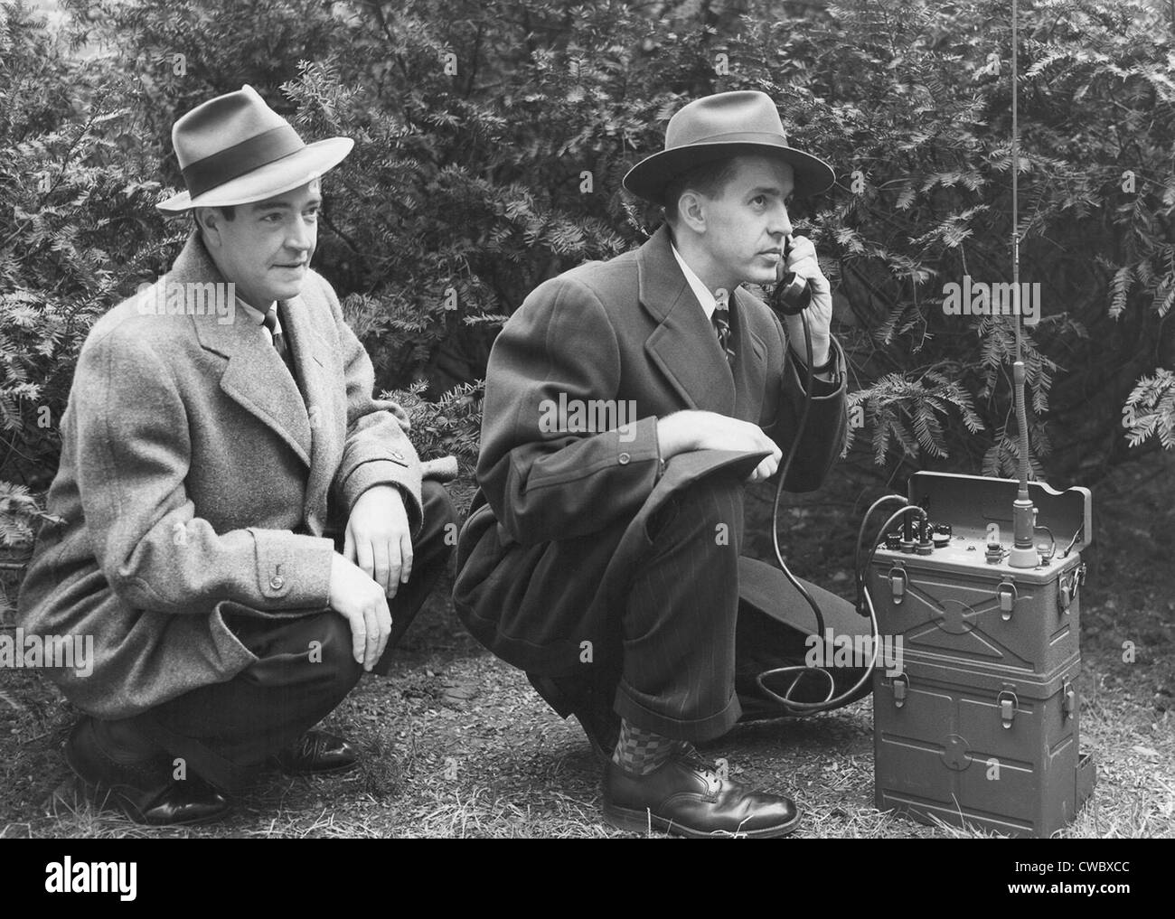 FBI agent with an huge portable phone during a kidnapping stakeout. Ca. 1940s. Stock Photo