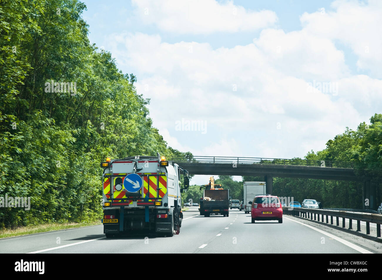 Escort Vehicle, with arrow, behind a slow moving lorry, to encourage overtaking on a UK motorway. Stock Photo