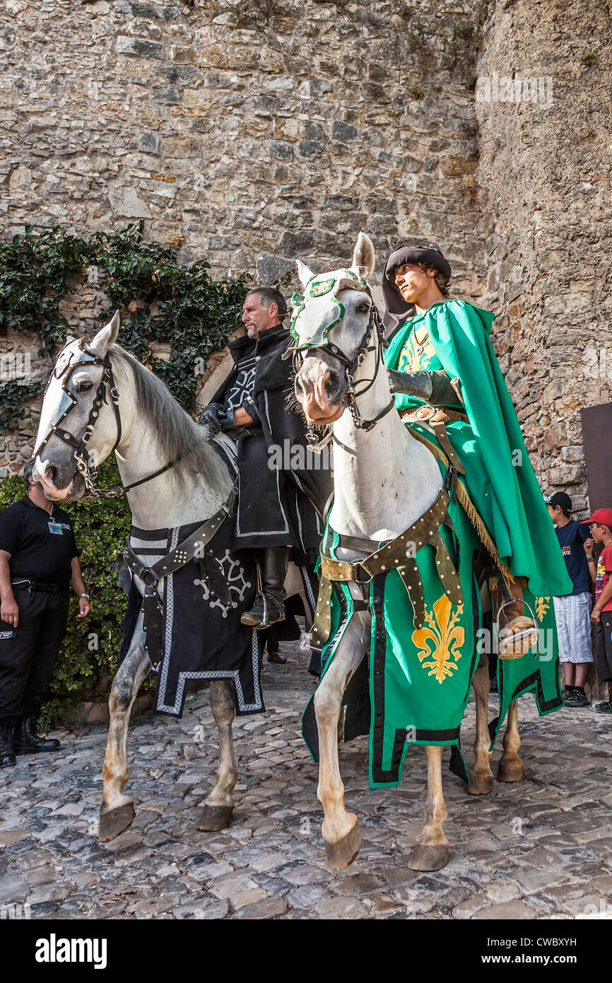 Knights riding white horses in a reenactment of a Medieval Fair in ...