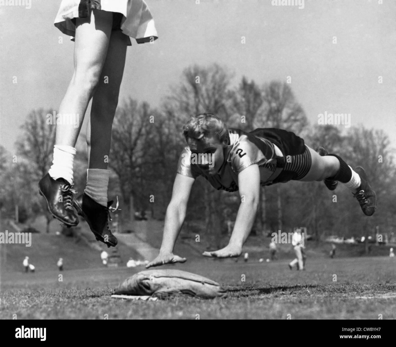 Linda McConkey, of the Atlanta's Lorelei Ladies softball team, diving for third base. The legs belong to Atlanta Tomboys third Stock Photo