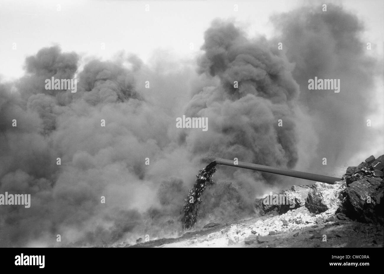 Clouds of black smoke obscure fire on an Iraq Petroleum Company well in the Kirkuk District of Iraq. 1932. Stock Photo