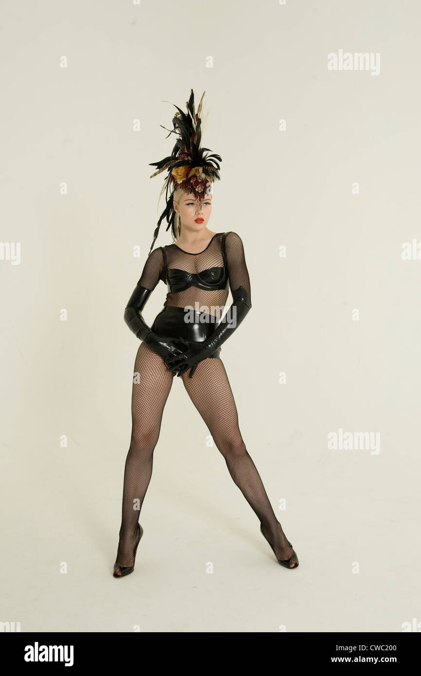 Pinup woman wearing fishnet stockings and leather posing over colored background Stock Photo
