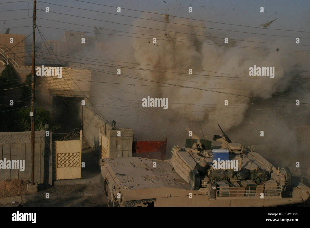 A U.S. Marine Corps Abrams tank blasts into a building from which they received fire in Fallujah Al Anbar province Iraq. Dec. Stock Photo