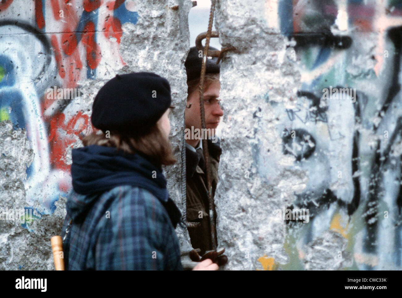 A young West German woman speaks with an East German guard through an opening in the Berlin Wall. Dec. 21 1989. Stock Photo