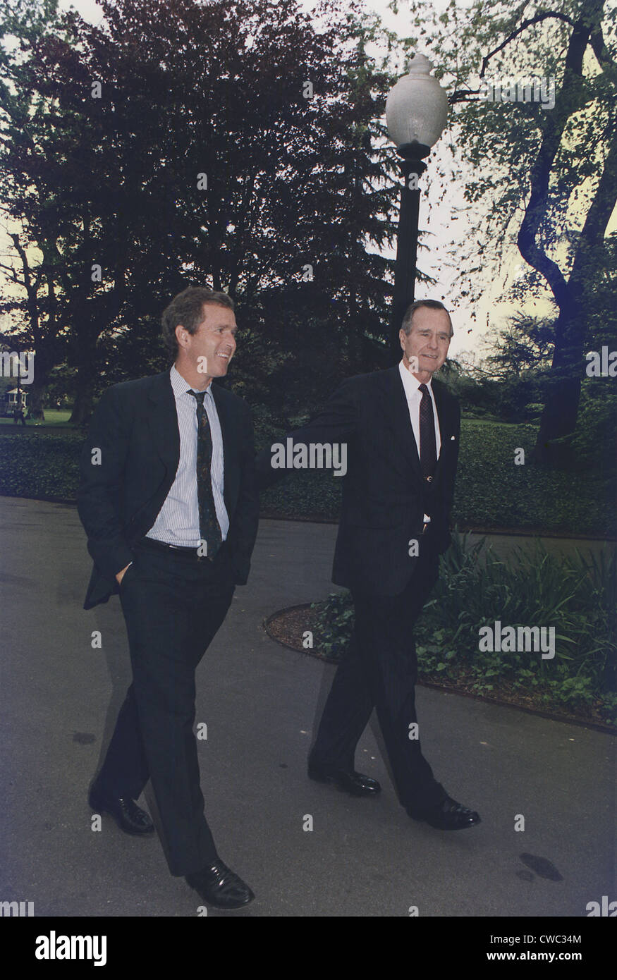 President George H.W. Bush walks on White House grounds with his son George W. Bush then head of an investment group that owned Stock Photo