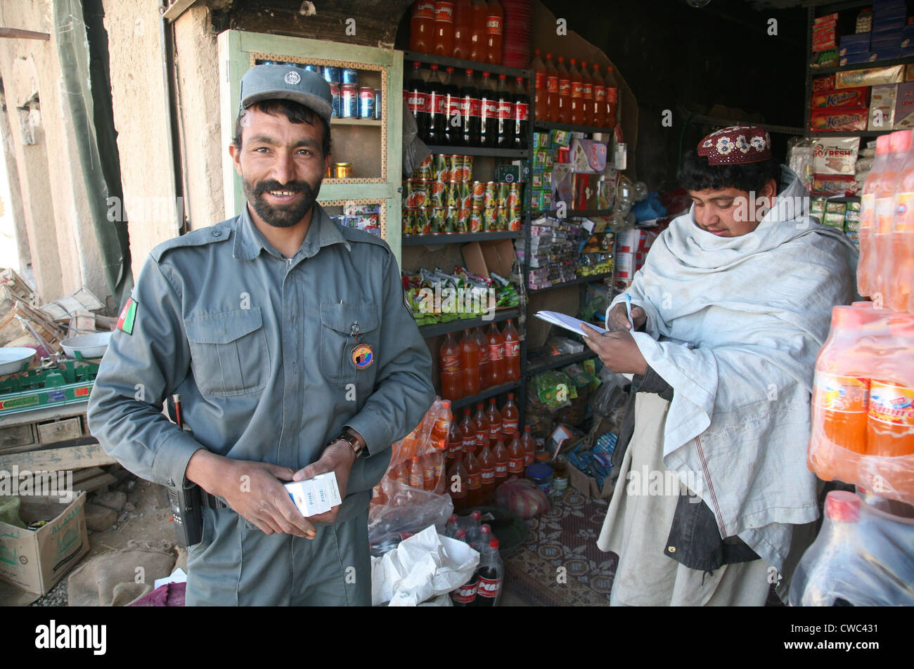 Afghan National Police officer shops at a store in Now Zad Helmand province Afghanistan. Residents have returned after the Stock Photo
