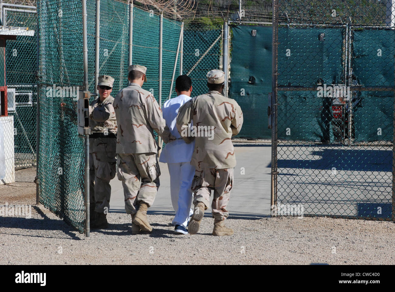 U.S. Navy guards escort a detainee through Camp Delta the military prison for enemy combatants many believed to be associated Stock Photo