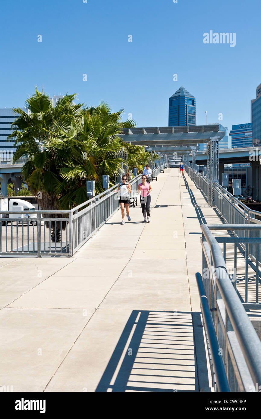 Joggers and walkers on the Northbank Riverwalk pedestrian bridge near