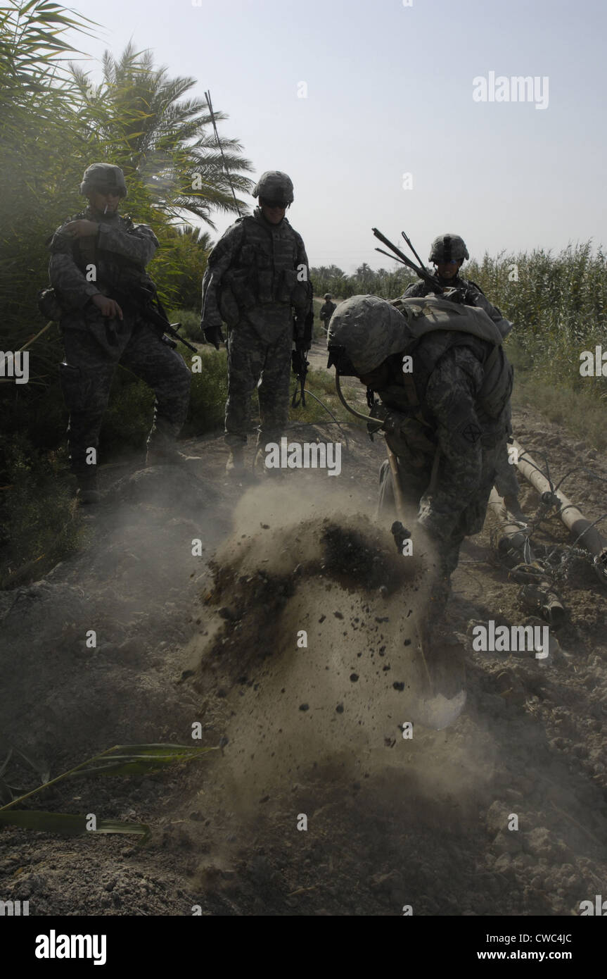 US Army Soldiers search for buried weapons at a remote village outside of Lutafiyah located in the southern sector of the city Stock Photo