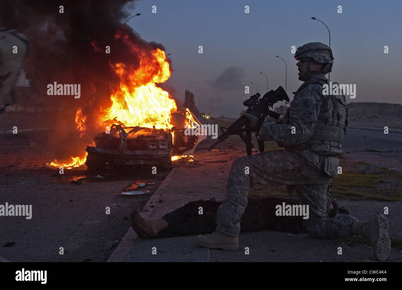 US Army soldier yells for a medic to treat an Iraqi civilian injured in a car bomb explosion in Mosul Iraq. March 6 2008. Stock Photo