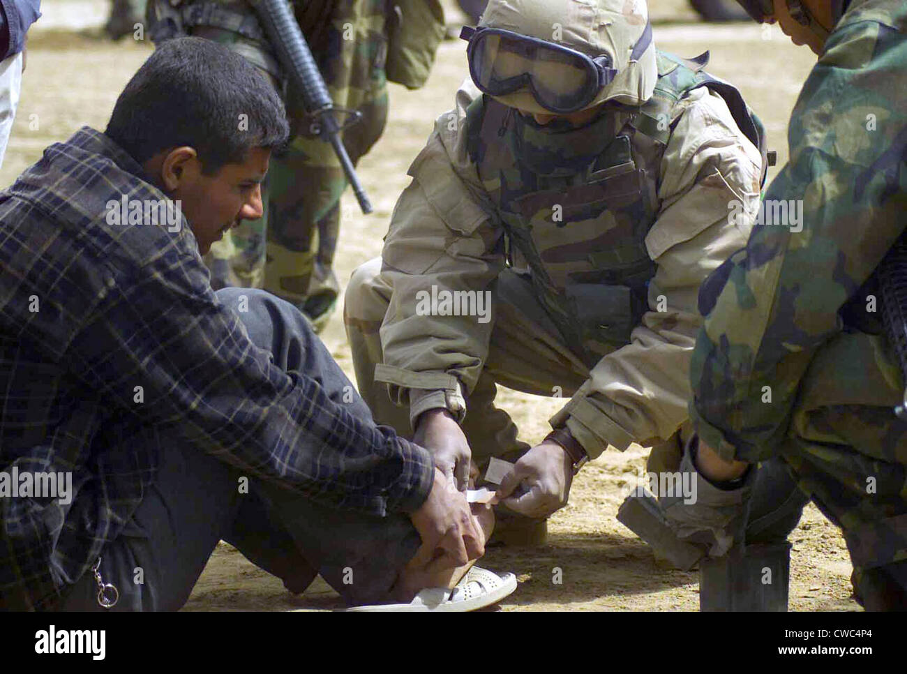 An Iraqi detainee receives a band-aid while under interrogation by a US Marine Corps in Al Shur Iraq during the first week of Stock Photo