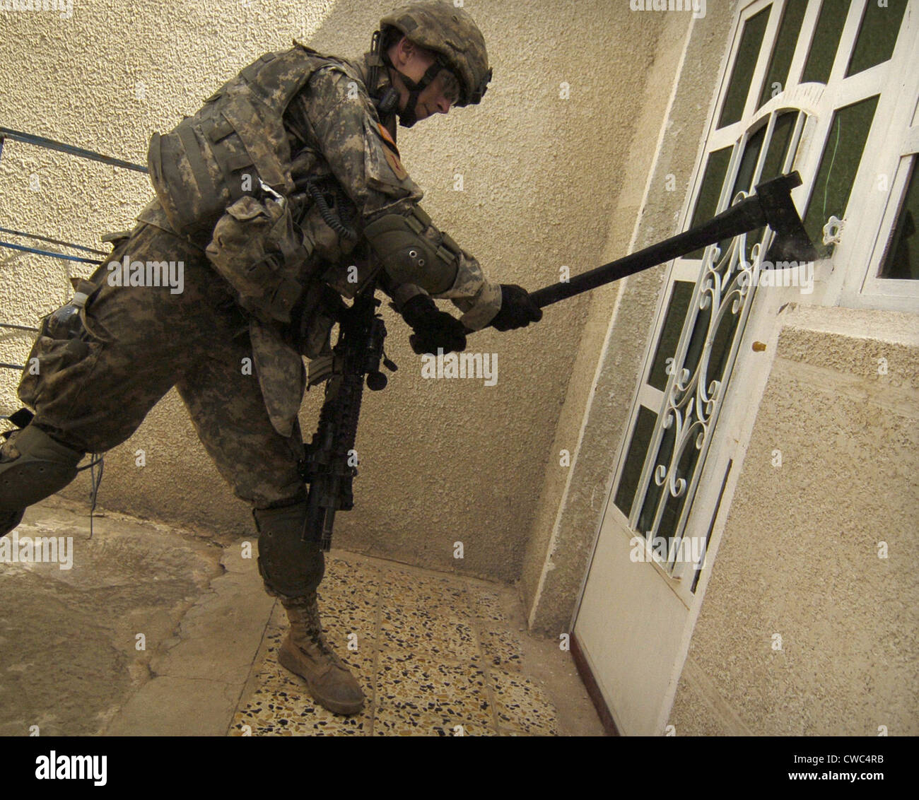 Us Soldier Breaks Down A Door During A House To House Search For