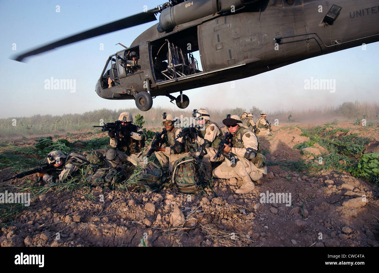 A Quick Response Force brace themselves in a security posture after being dropped off by a Black Hawk helicopter on a mission Stock Photo
