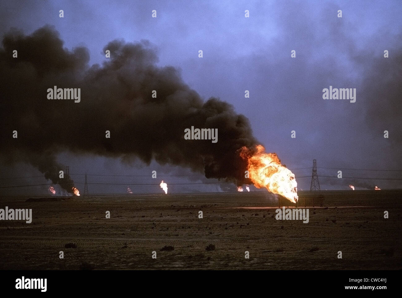 Kuwaiti oil wells set on fire by retreating Iraqi forces during Operation Desert Storm darken the sky with smoke. Mar. 1 1991 Stock Photo