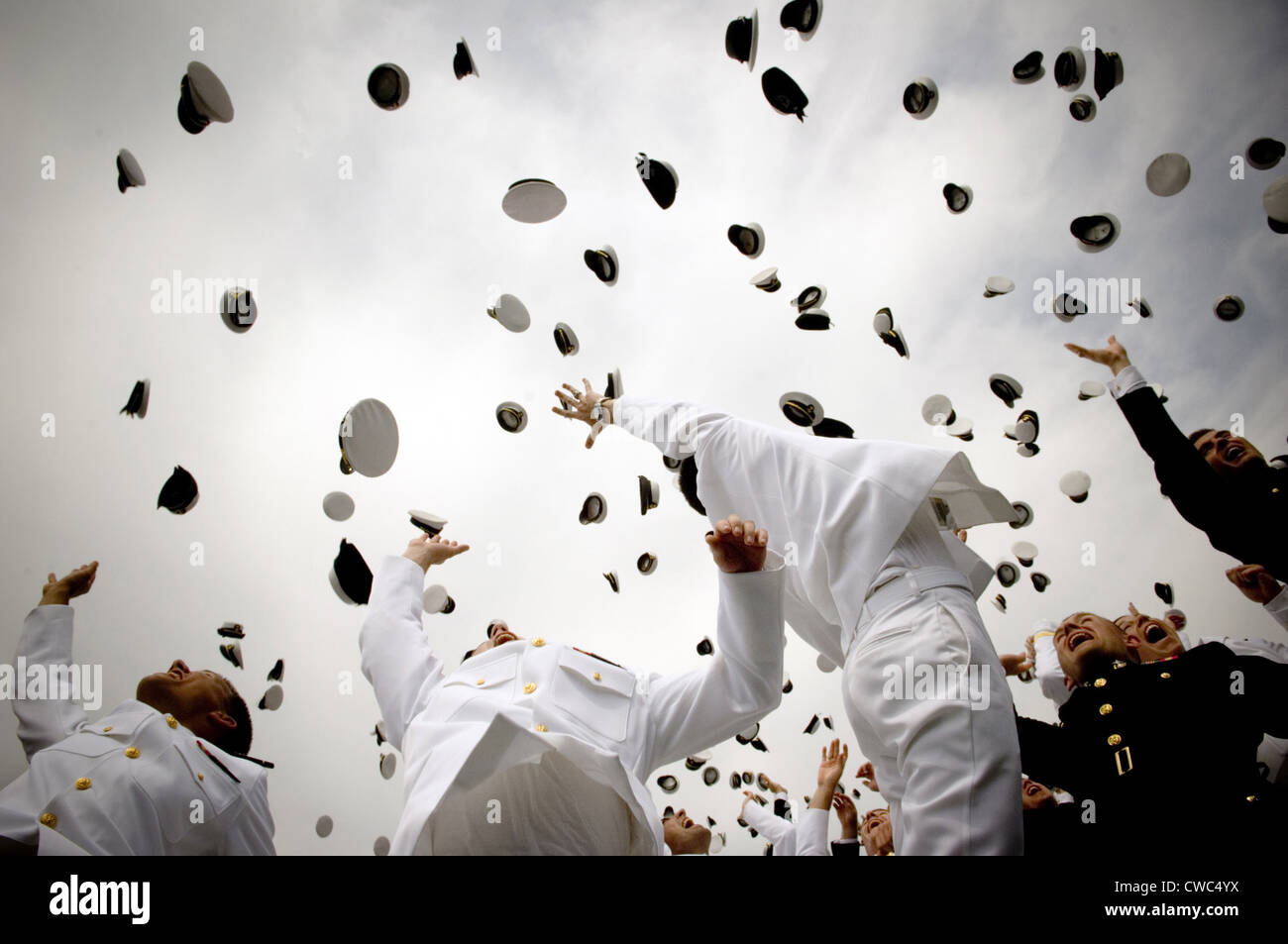 Newly commissioned Navy ensigns and Marine Corps 2nd Lieutenants toss their hats into the air at their 2006 graduation and Stock Photo