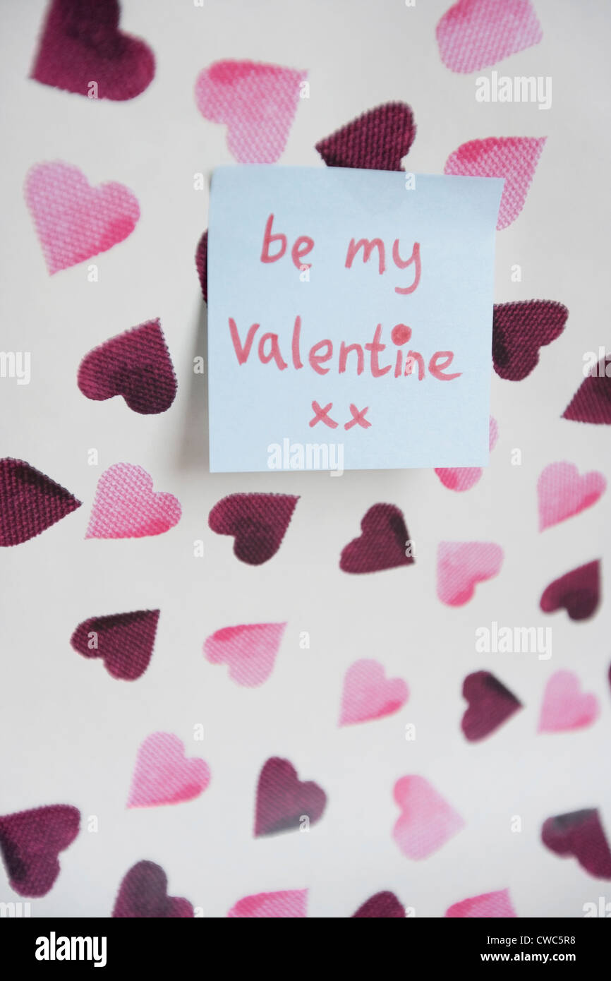 Close-up of sticky note with a orthographic message over heart shaped background Stock Photo