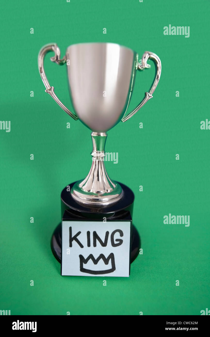 Trophy with sticky note over colored background Stock Photo
