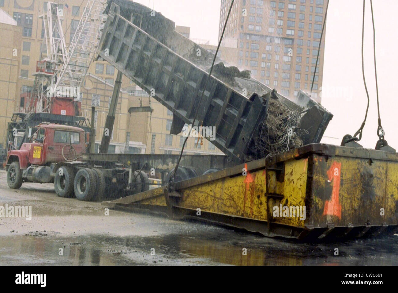 A few blocks from Ground Zero a truck dumps World Trade Center debris into the bucket of a 500-ton crane at a Hudson River Stock Photo