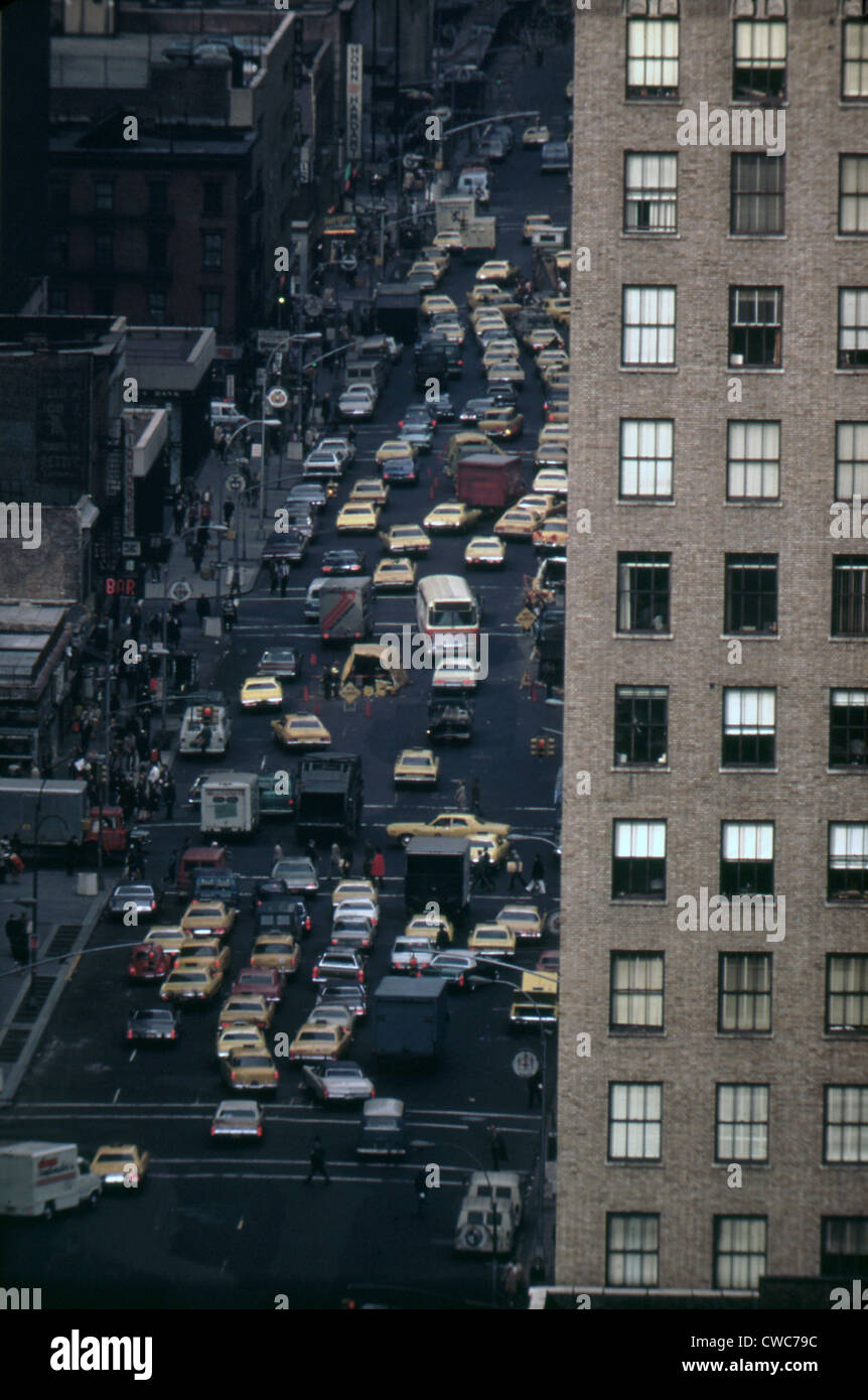 Traffic in New York City. View of vehicles on Manhattan's Sixth Avenue at 42nd Street is framed by a massive pre-war apartment Stock Photo