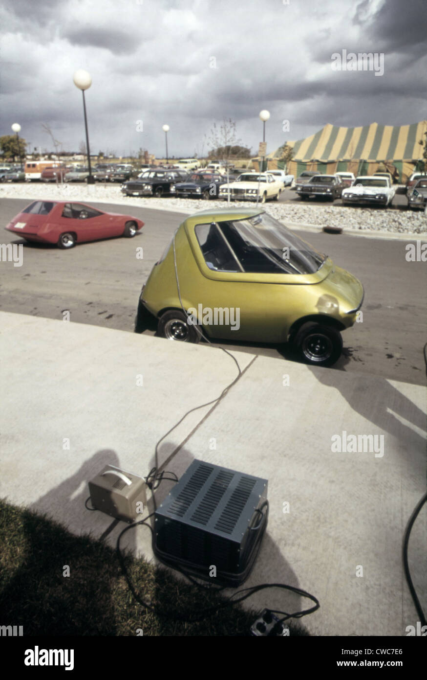 An General Motors urban electric car gets battery charge at a 1973