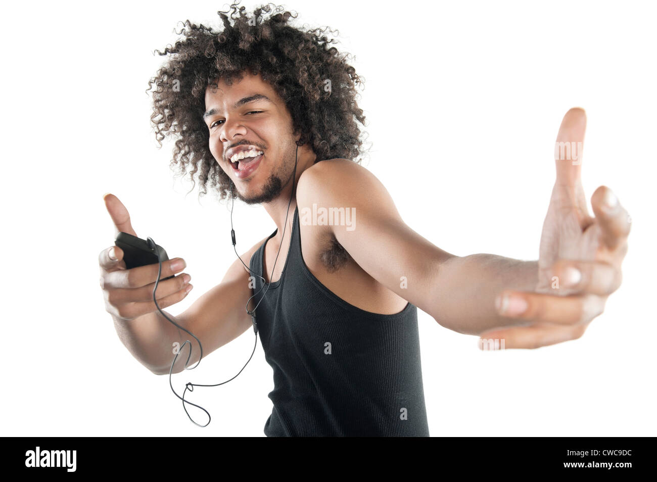 Portrait of a happy young man in vest dancing to tunes of mp3 player over white background Stock Photo