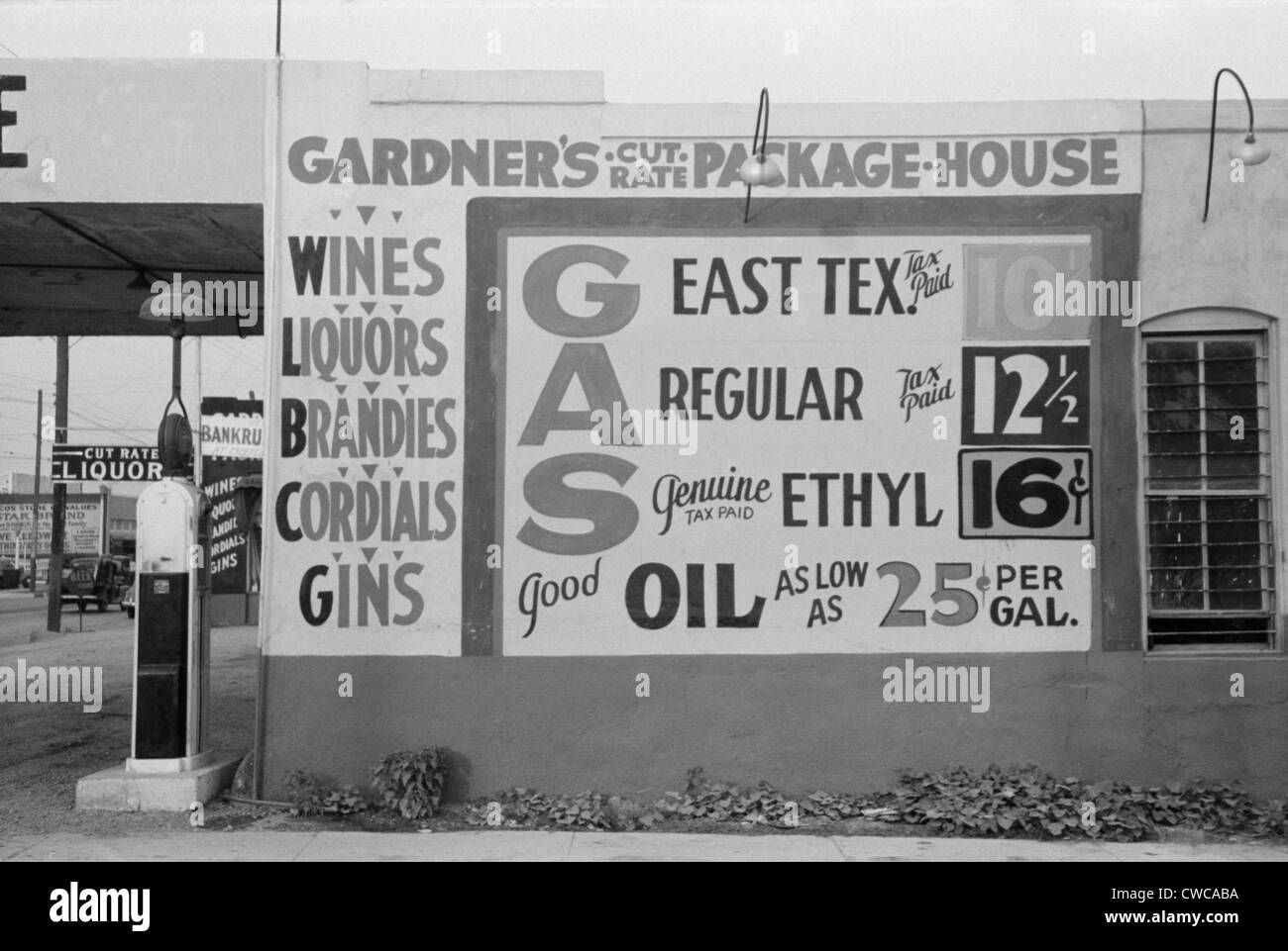 Gardener's Cut Rate Package House sign advertising alcoholic beverages and gasoline prices. Waco, Texas, Nov. 1939. Stock Photo