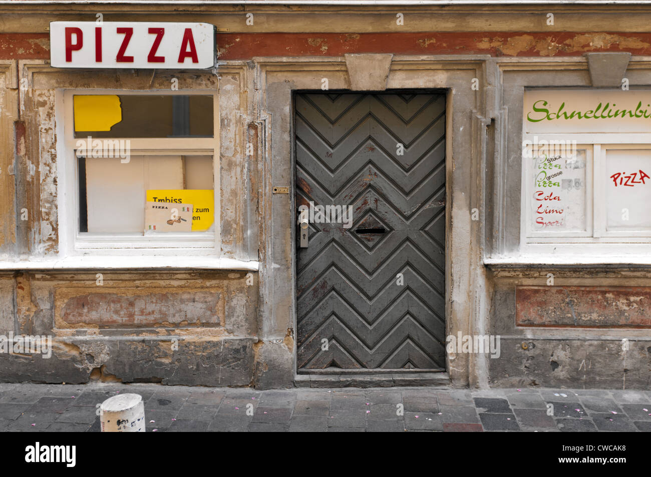 Old worn pizzeria front boarded up, Germany. Stock Photo