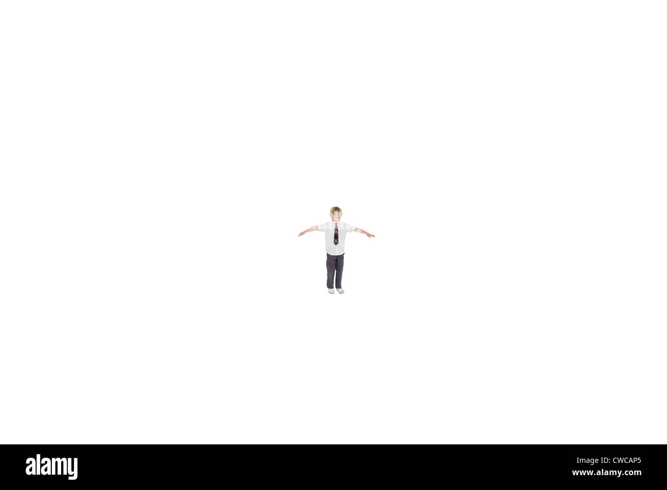 Elementary boy standing at distance with arms outstretched over white background Stock Photo