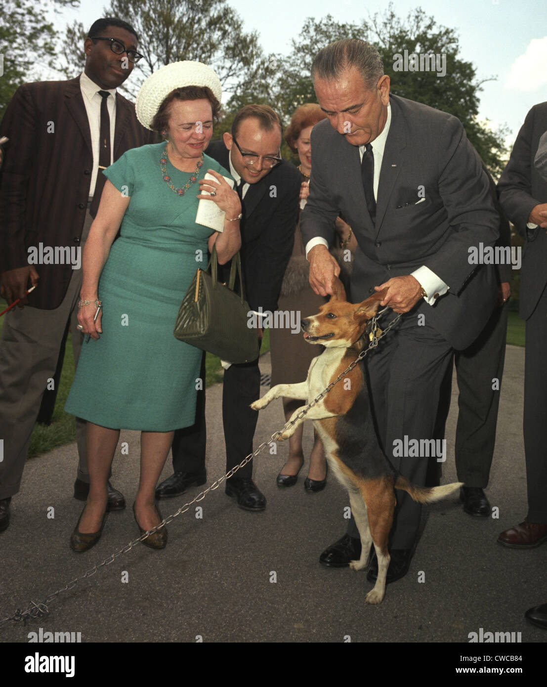 President Lyndon Johnson holds his beagle up by the ears as members of the press look on. May 4, 1964. Stock Photo