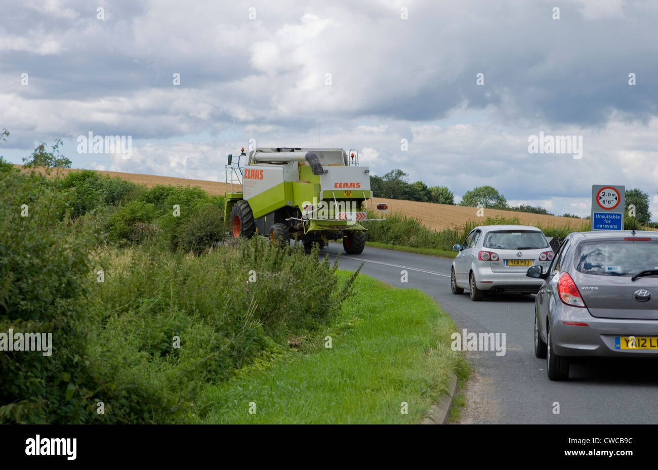 Tractor blocking road holding up traffic Stock Photo