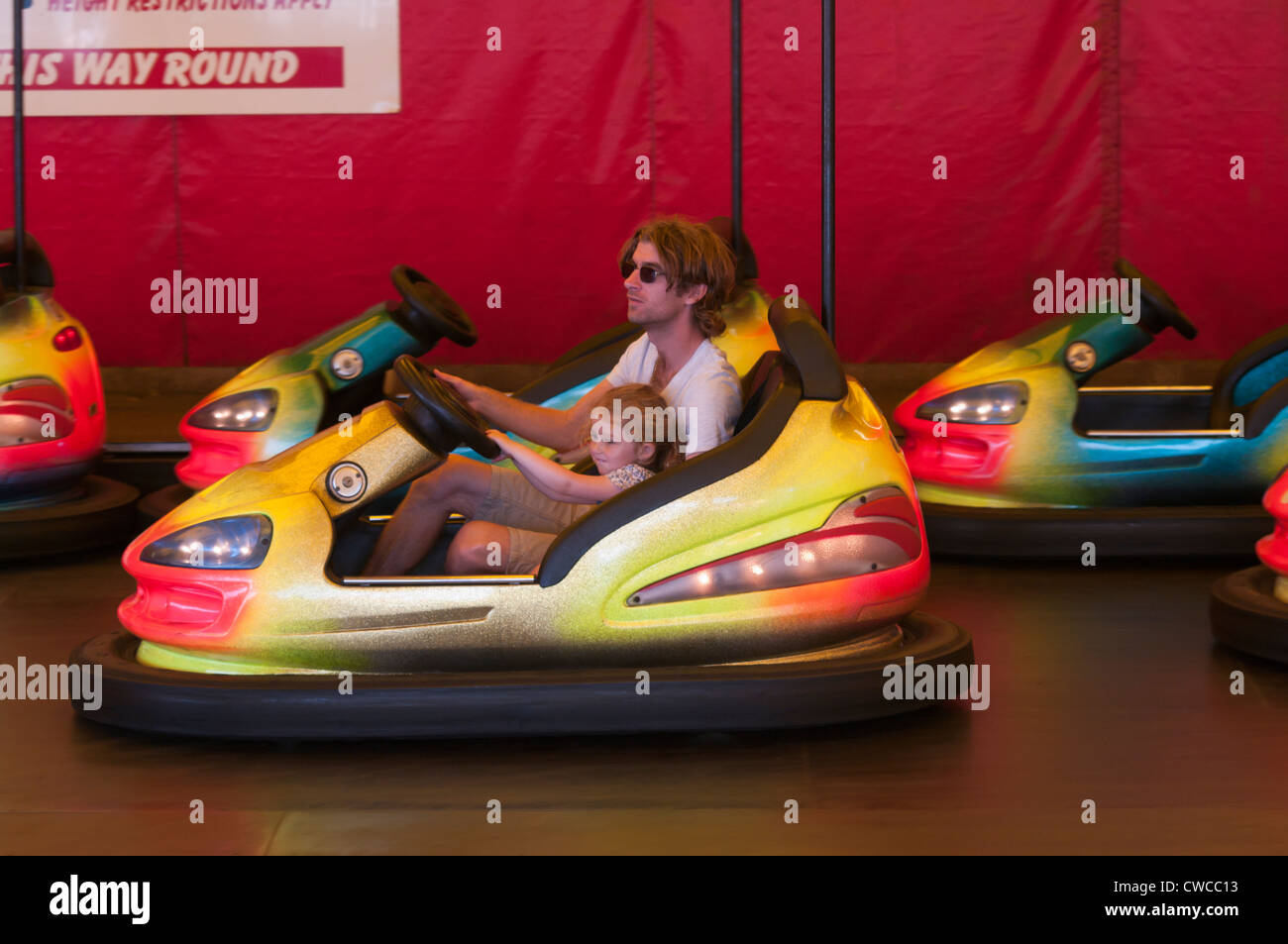 Father and Daughter On A Fairground Bumper Car UK Fairgrounds Funfairs