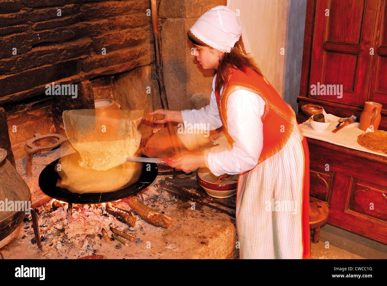 France, Brittany: Laurille baking crepe in the Museum village of Poul-Fetan Stock Photo