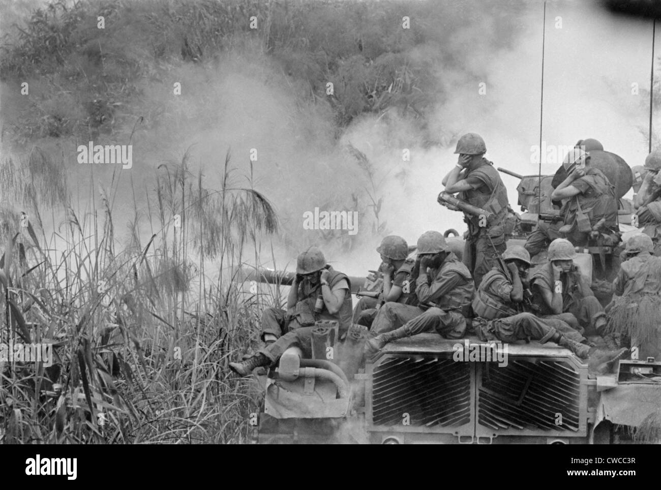 Vietnam War. Marines riding atop an M-48 tank cover their ears as the 90mm gun fires southwest of Phu Bai. April 5, 1968. Stock Photo