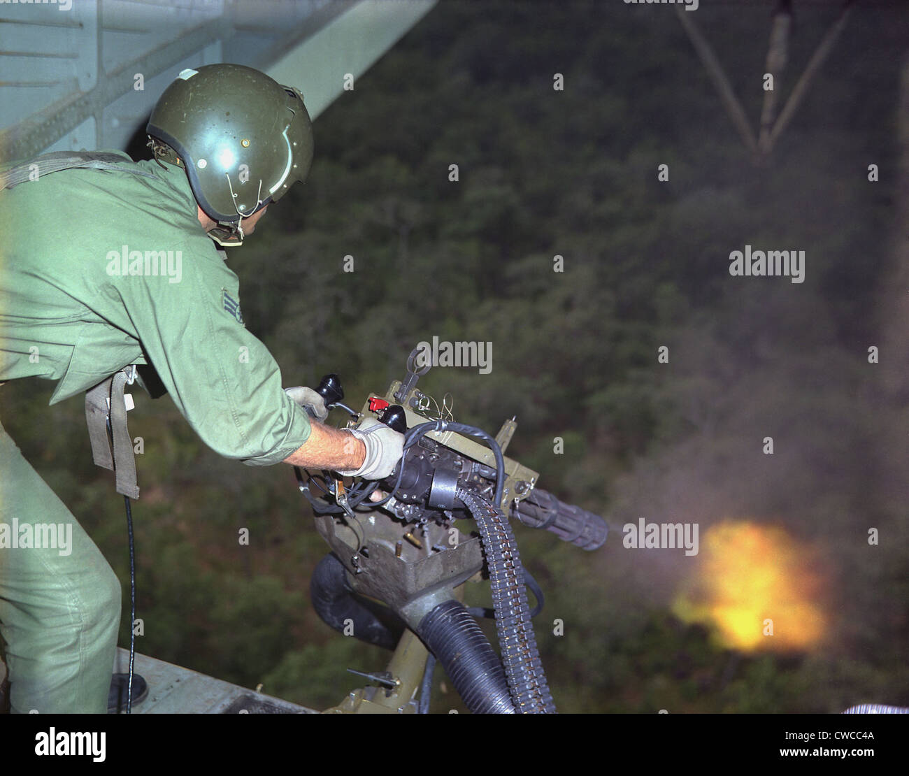 Vietnam War. US Air Force helicopter door gunner fires a mini-gun during a rescue patrol over South Vietnam. Oct. 10, 1968. Stock Photo