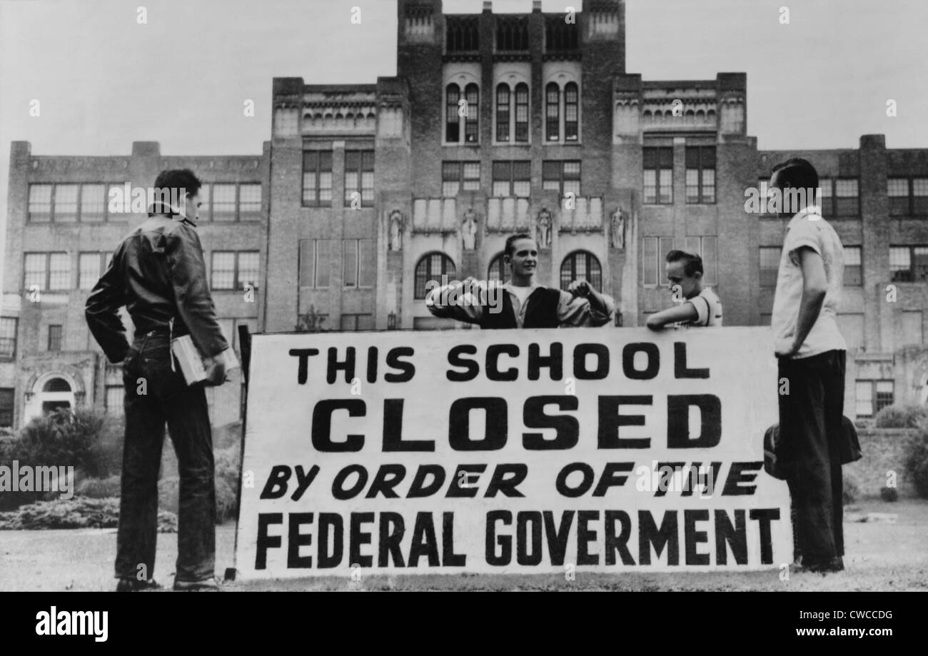 Little Rock Central High was closed to avoid integration. Four students pose with a large sign reading 'This school closed by Stock Photo