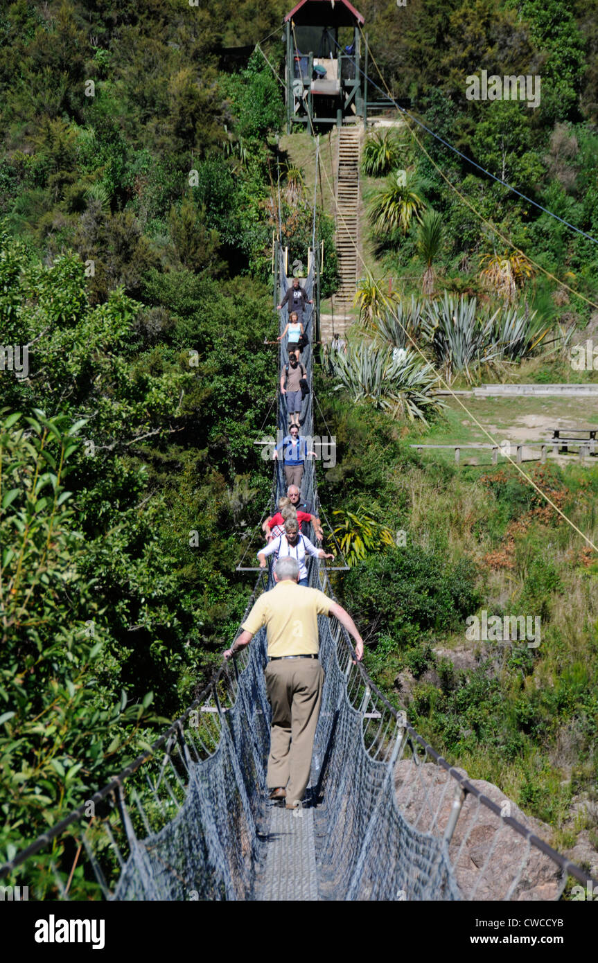 Two-way traffic as visitors cross New Zealand's longest swing bridge high above the Buller river at Buller Gorge in New Zealand Stock Photo