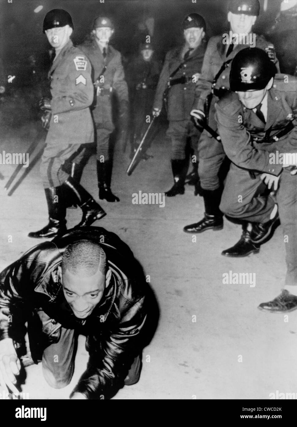 Disorder in 'Birmingham of the North,' Chester, Pennsylvania. African American man crouches on the ground as he reacts to night Stock Photo