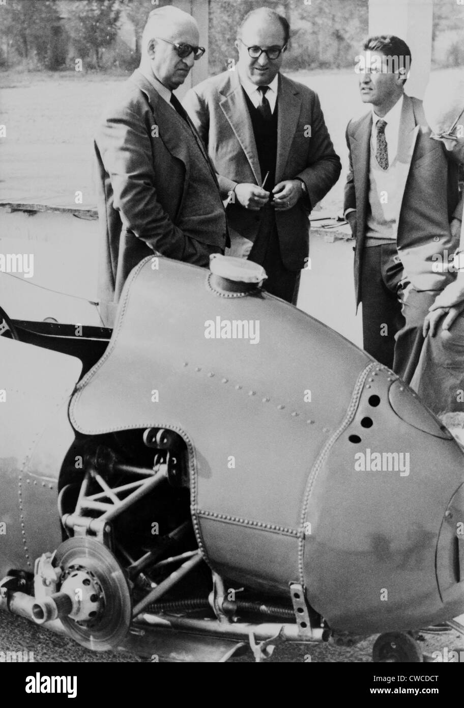 Enzo Ferrari (left), founder and owner of the Ferrari Auto factories Modena, Italy, looks over a 1959 racing car with Stock Photo