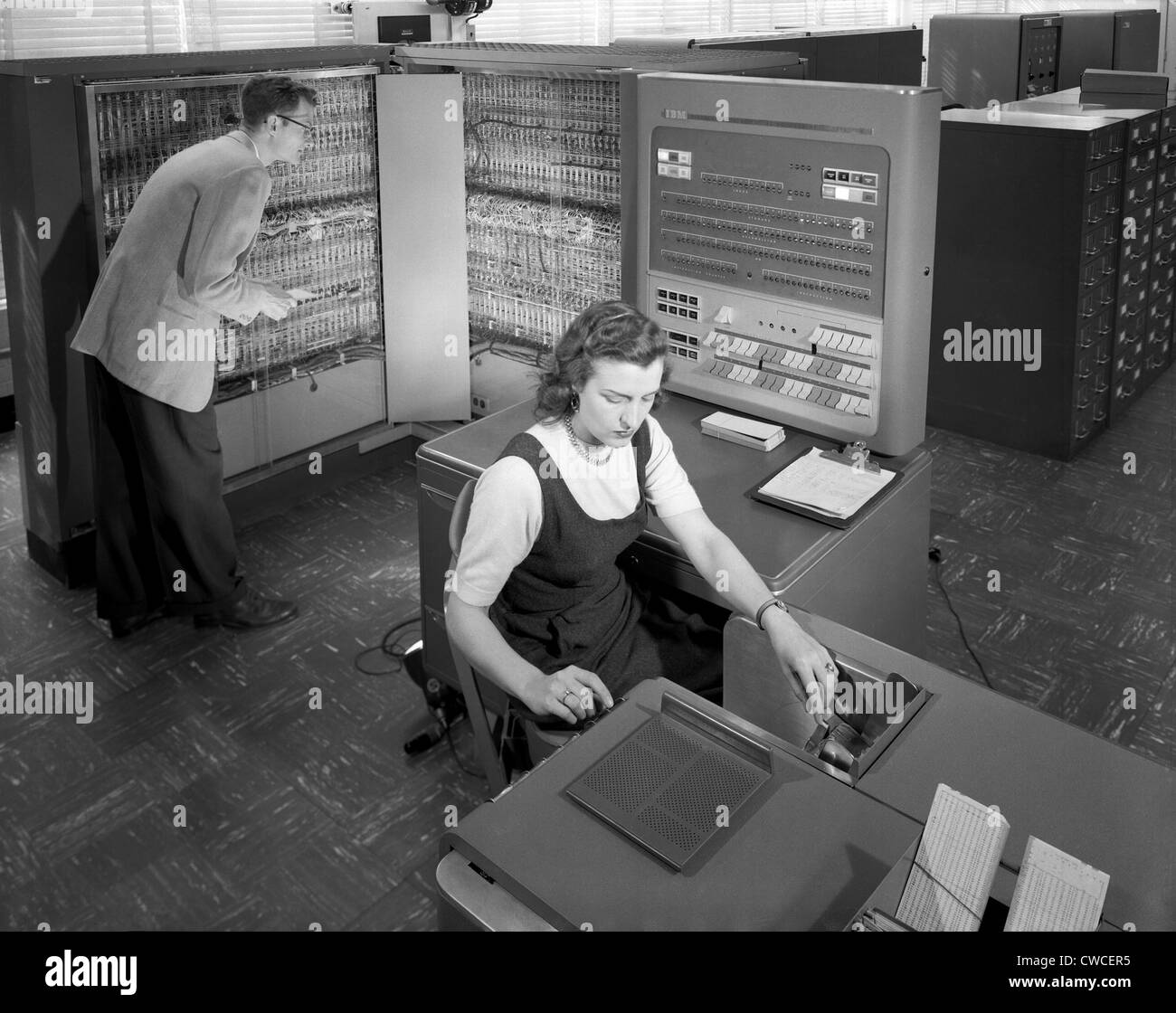 Technicians working with room size IBM type 704 computer making calculations for aeronautical research. NASA Langley Research Stock Photo