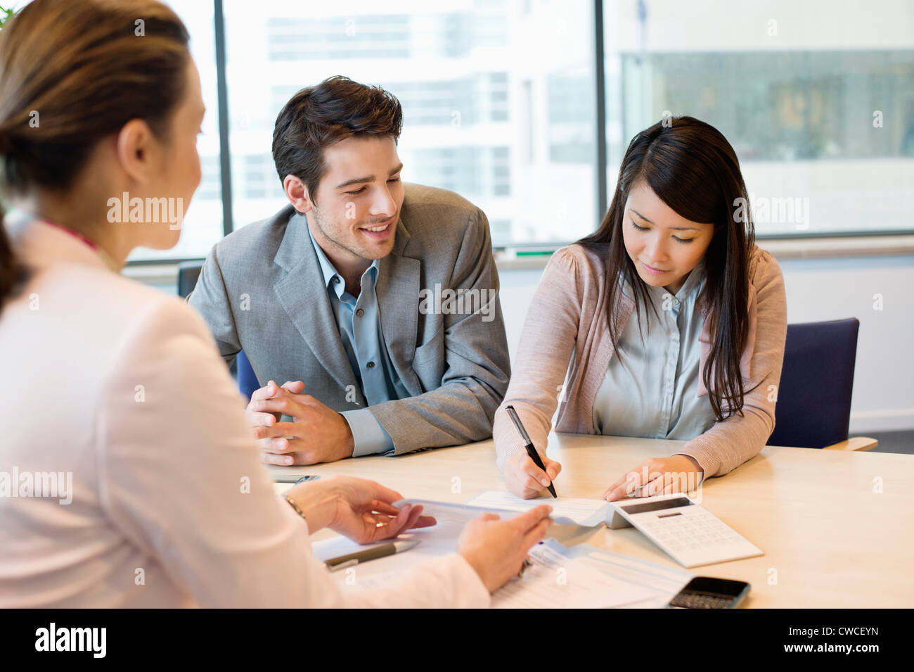 Couple signing documents with real estate agent Stock Photo Alamy