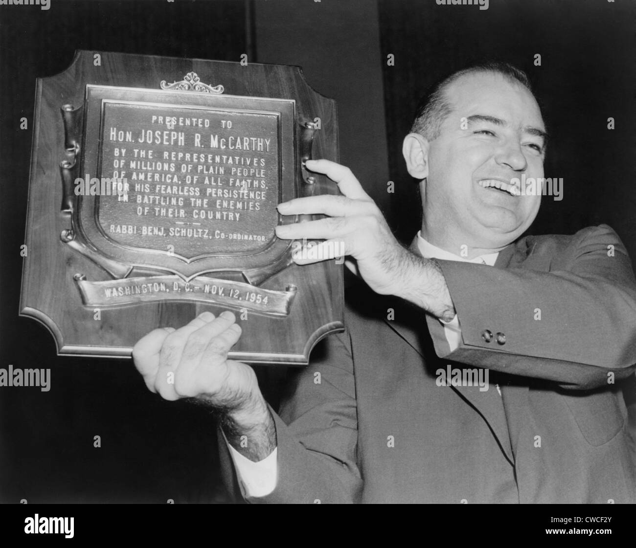 Wisconsin Senator Joseph McCarthy displays a plaque honoring him '…for his fearless persistence in battling the enemies of Stock Photo