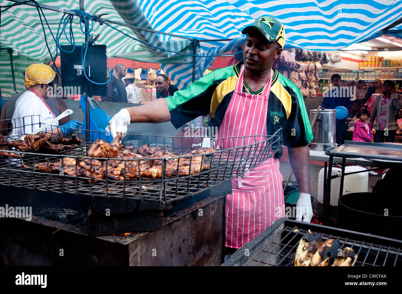 Man cooking and selling cooking Jerk chicken at Brixton street party Stock Photo