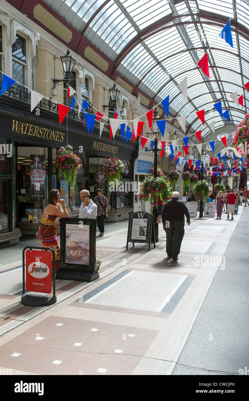 Victorian shopping arcade with shoppers and red white and blue bunting in Bournemouth Dorset UK